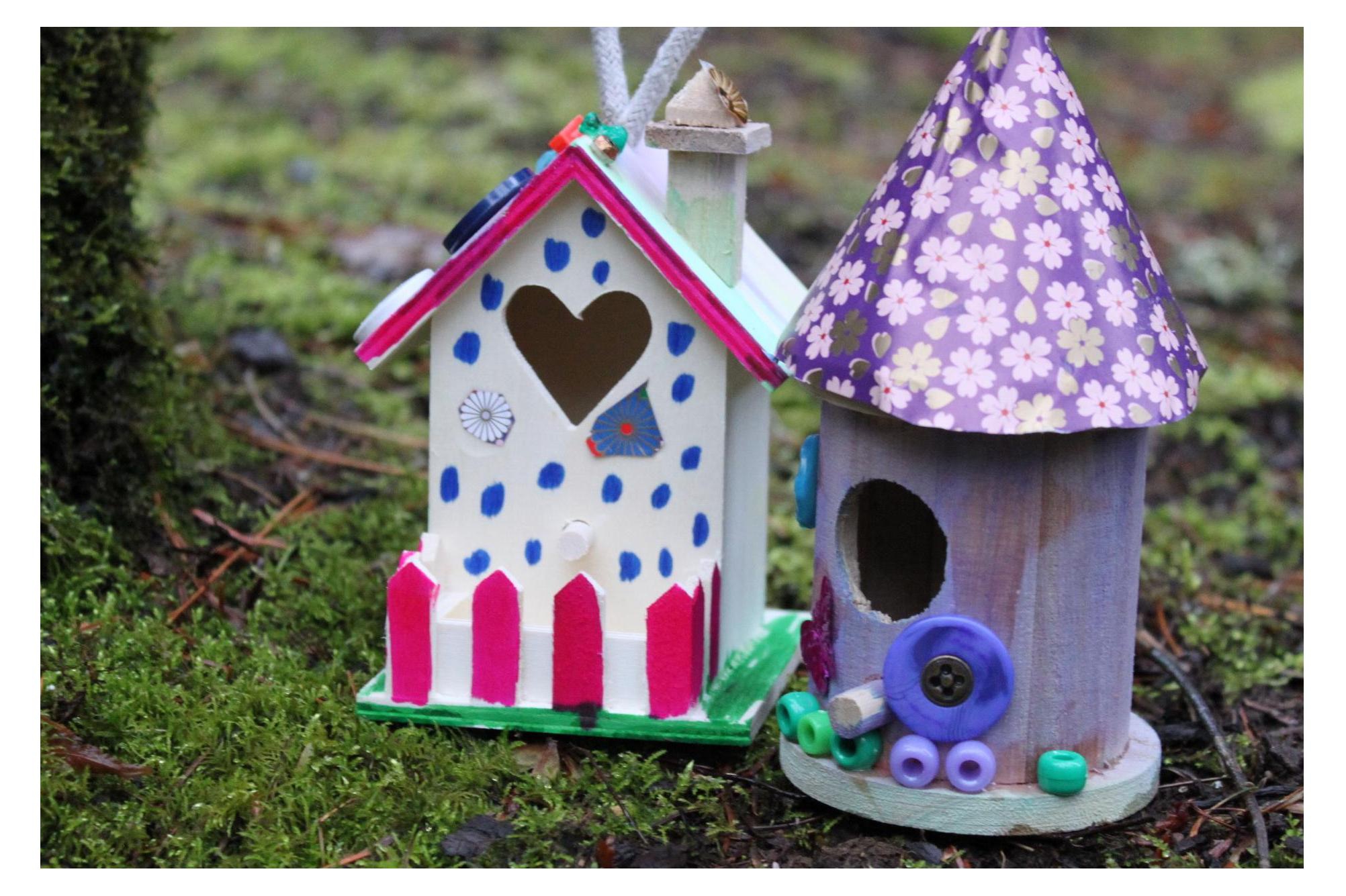 two homemade fairy houses in the grass